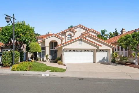 a view of a white house with a street