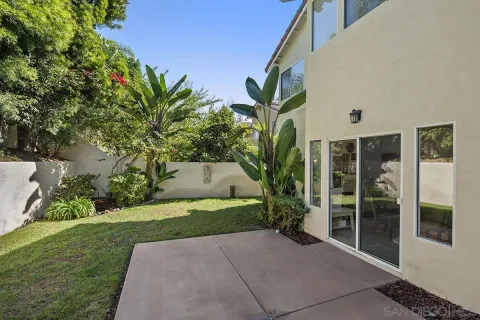 a porch with a yard and potted plants
