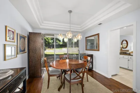 a dining room with furniture a chandelier and wooden floor