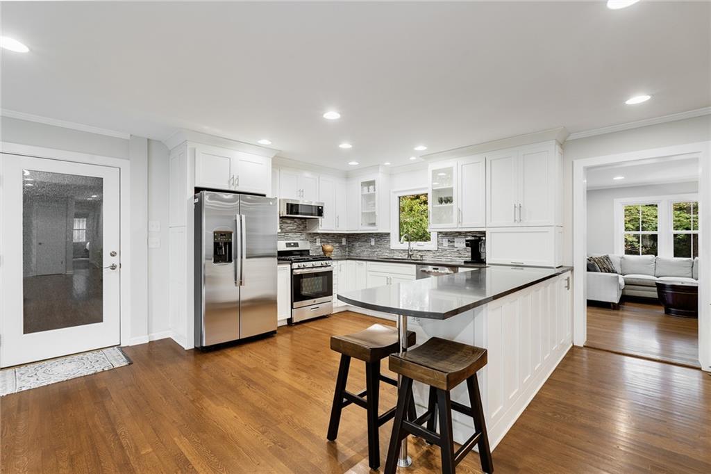 6555 Wright Road Northeast Sandy Springs, GA 30328 - Photo 6 of 40 a kitchen with a dining table chairs refrigerator and cabinets