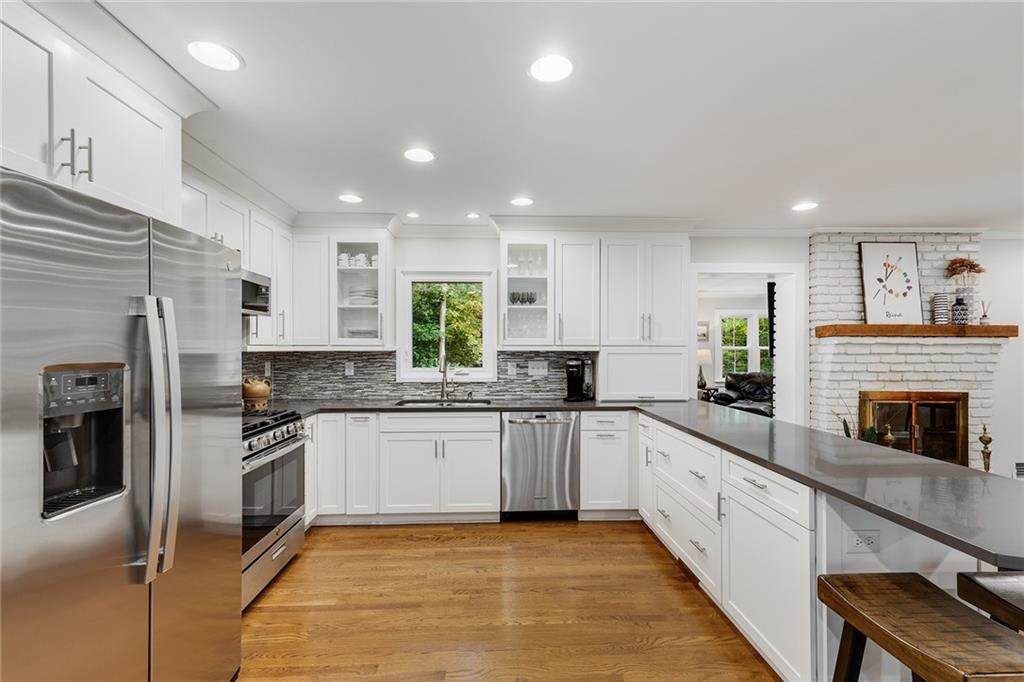 6555 Wright Road Northeast Sandy Springs, GA 30328 - Photo 7 of 40 a large kitchen with granite countertop stainless steel appliances and white cabinets