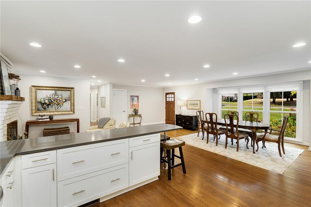 6555 Wright Road Northeast Sandy Springs, GA 30328 - Photo 8 of 40 a open kitchen with stainless steel appliances granite countertop a dining table chairs stove and white cabinets