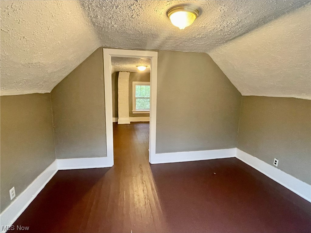857 Aberdeen Street Akron, OH 44310 - Photo 19 of 23 Bonus room featuring a textured ceiling, dark hardwood flooring, and vaulted ceiling