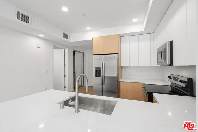 a kitchen with stainless steel appliances a refrigerator sink and stove