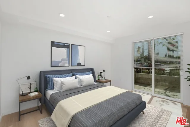 a bedroom with a balcony a bed and a large window