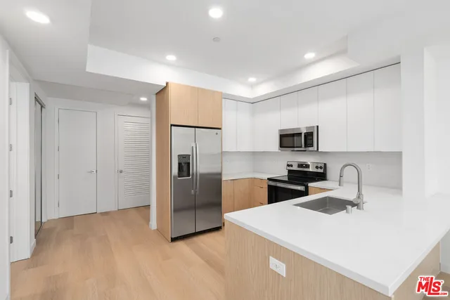 a kitchen with stainless steel appliances a refrigerator sink and microwave