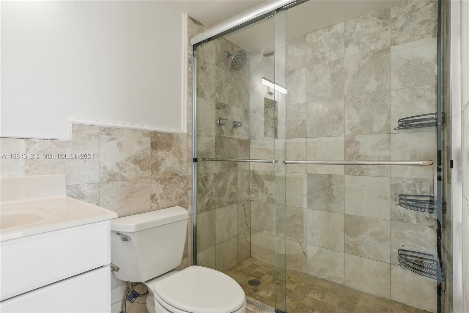 550 Ocean Drive, Unit 9F Key Biscayne, FL 33149 - Photo 13 of 37 a white toilet sitting next to a bathroom sink