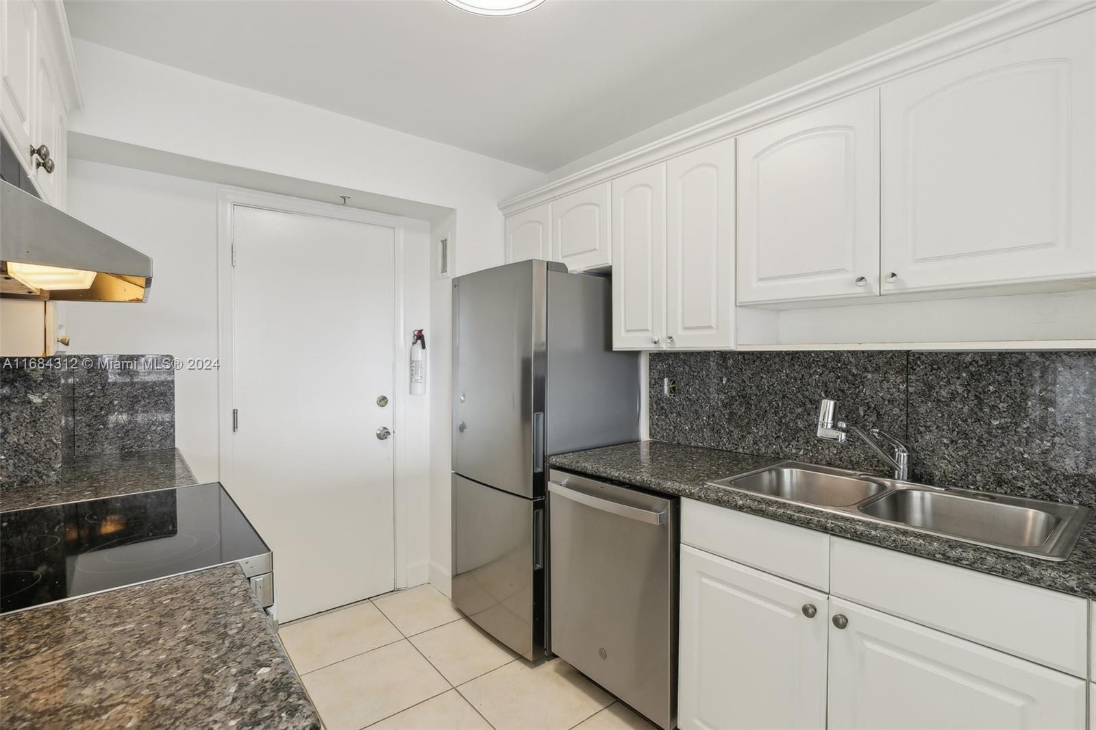 550 Ocean Drive, Unit 9F Key Biscayne, FL 33149 - Photo 28 of 37 a kitchen with stainless steel appliances granite countertop a refrigerator and a sink