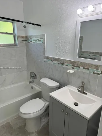a bathroom with a sink mirror toilet and bathtub