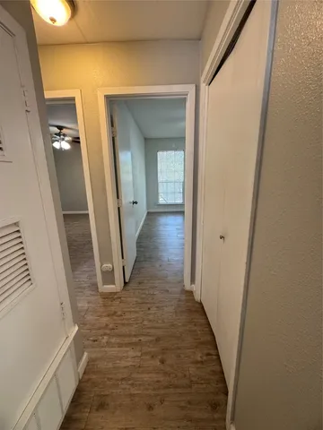 a view of a hallway with wooden floor and staircase