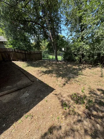 a view of a backyard with large trees