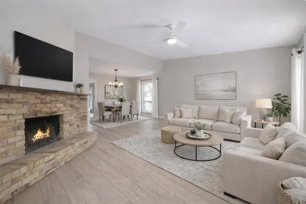 a living room with furniture a flat screen tv and a fireplace