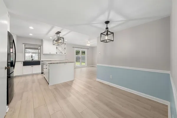 a view of a kitchen with wooden floor a sink and dishwasher
