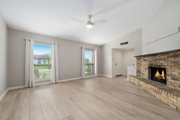 a view of an empty room with window and fire place