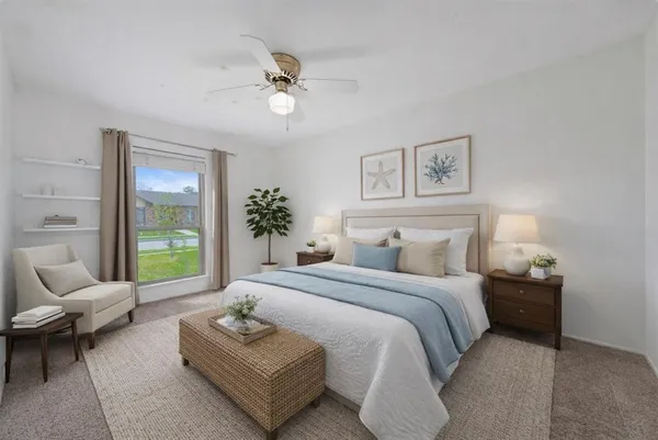 a bedroom with a bed couches chair and next to a window