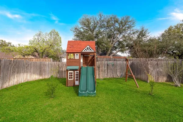 a sign board with huge green field and wooden fence