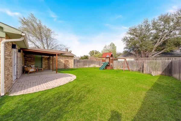 a view of a house with backyard and a tree