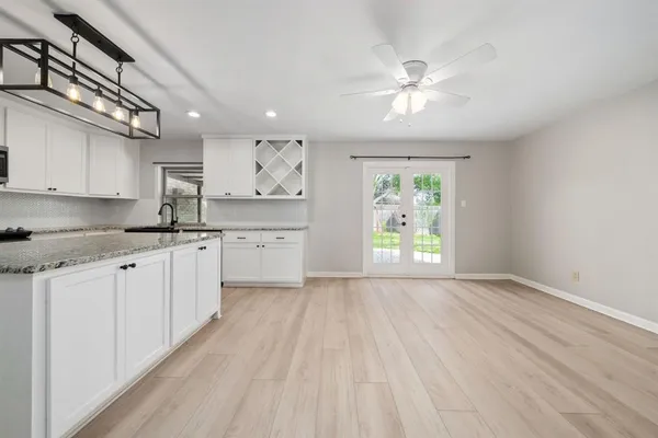 a open kitchen with kitchen island white cabinets and white appliances