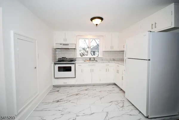 a kitchen with a stove a refrigerator and a sink