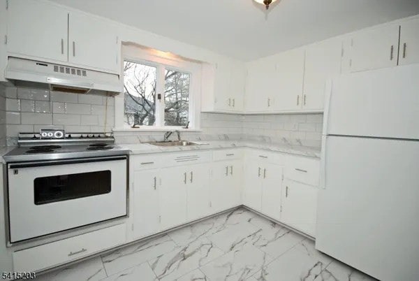 a kitchen with granite countertop white cabinets and white appliances