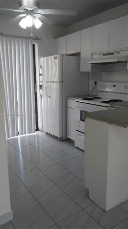 a kitchen with a refrigerator sink and cabinets