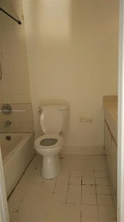 a white toilet sitting next to a bath tub