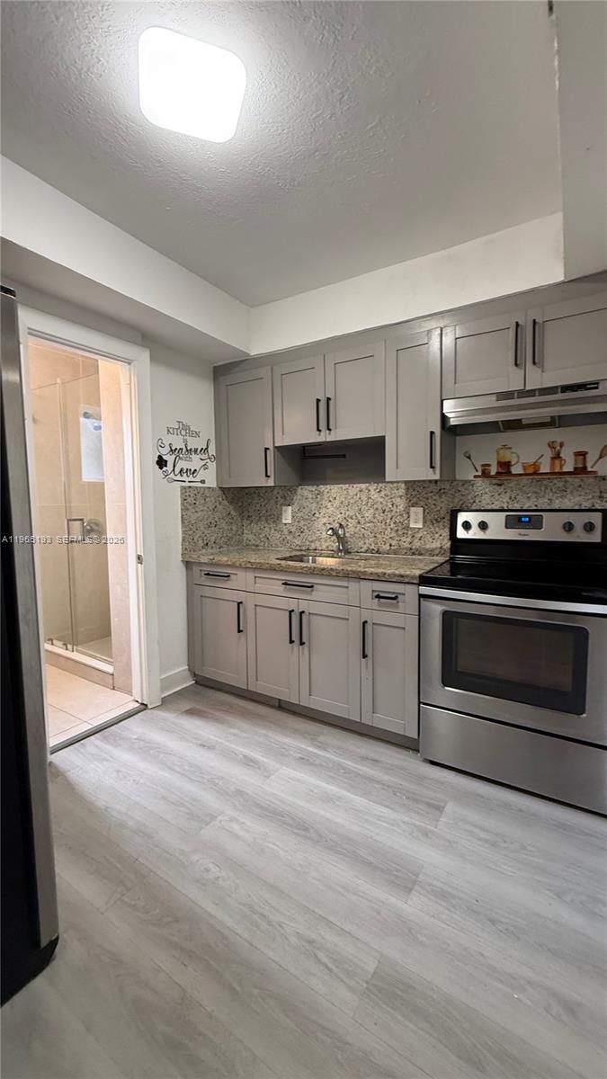 2238 Northwest 5th Street, Unit 1 Miami, FL 33125 - Photo 1 of 18 a kitchen with stainless steel appliances granite countertop a stove a sink and a refrigerator