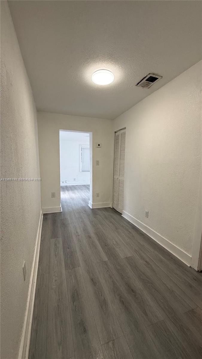 2238 Northwest 5th Street, Unit 1 Miami, FL 33125 - Photo 12 of 18 an empty room with wooden floor and windows