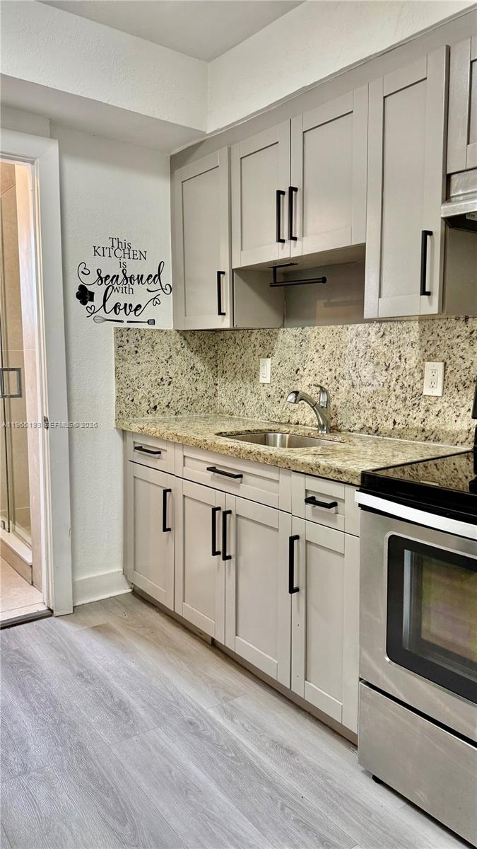 2238 Northwest 5th Street, Unit 1 Miami, FL 33125 - Photo 2 of 18 a kitchen with granite countertop cabinets stainless steel appliances and a sink