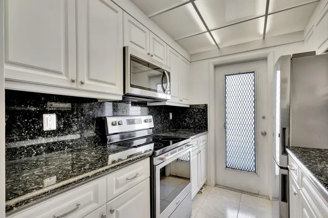 a kitchen with stainless steel appliances granite countertop a stove and a microwave