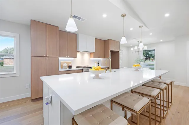 a kitchen with kitchen island a stove a table and chairs