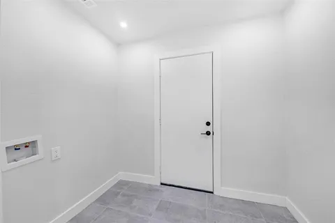 a view of a house with a small yard and a large tree