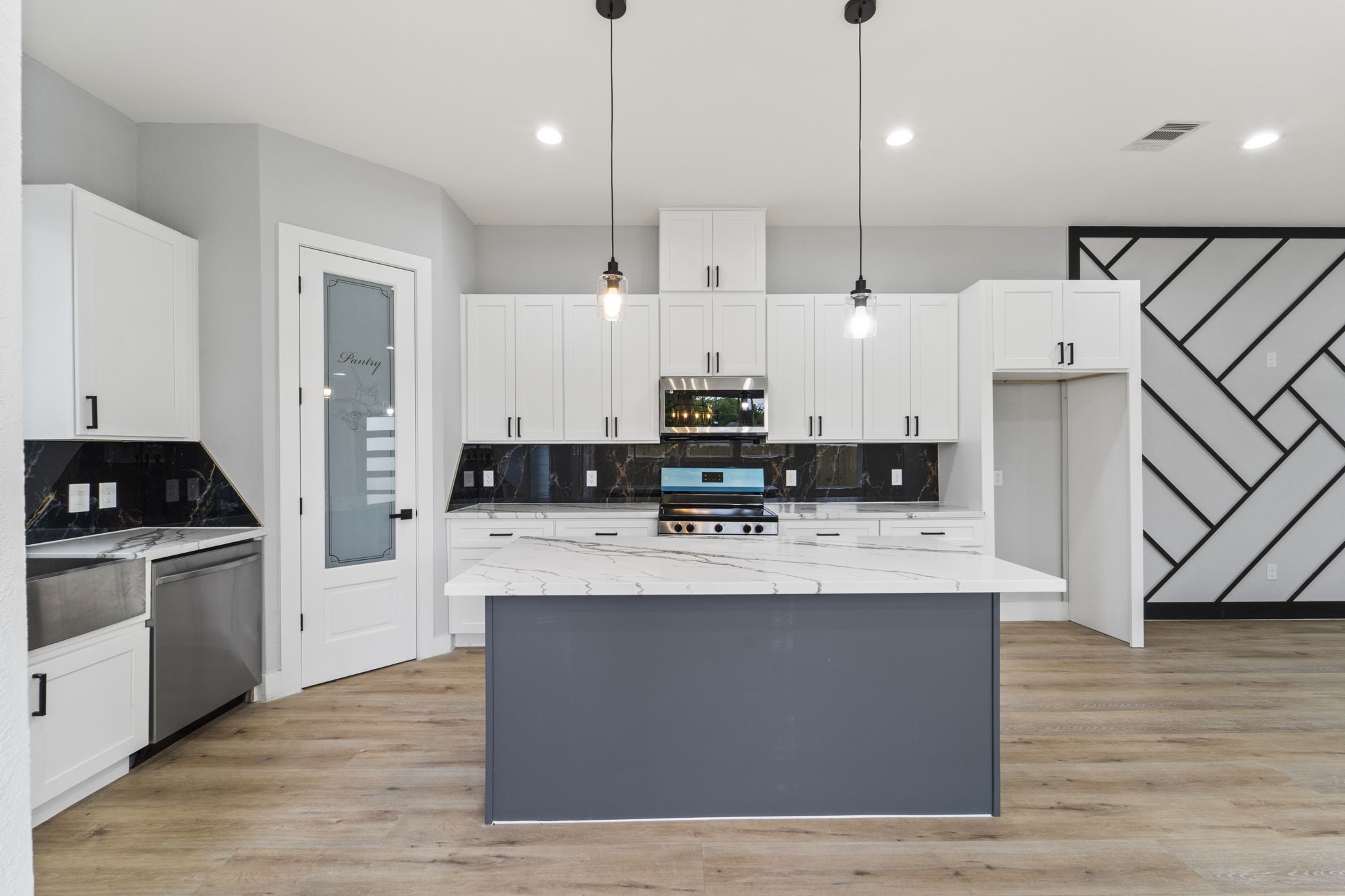 6631 Foster Street Houston, TX 77021 - Photo 4 of 21 a large white kitchen with stainless steel appliances granite countertop a stove a oven a refrigerator white cabinets with wooden floor
