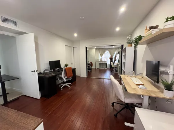 a view of a workspace with furniture and wooden floor