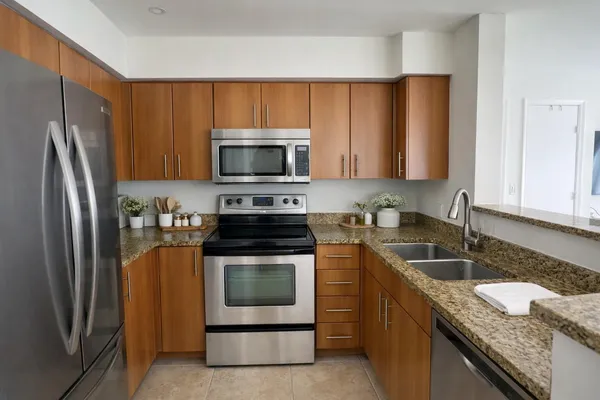 a kitchen with granite countertop a sink stove and refrigerator