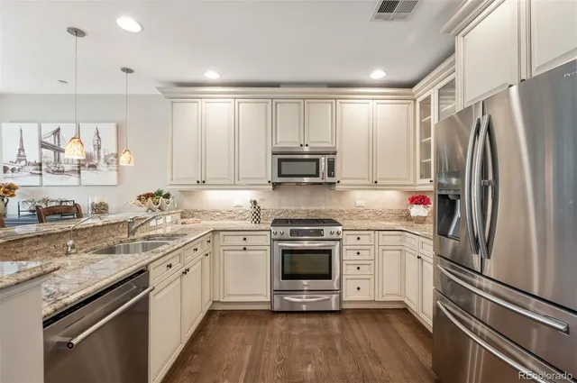a kitchen with stainless steel appliances granite countertop a sink stove and refrigerator