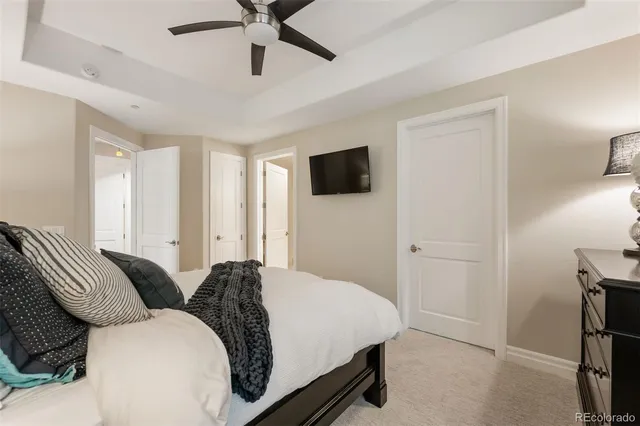 a spacious bedroom with a bed and a flat screen tv