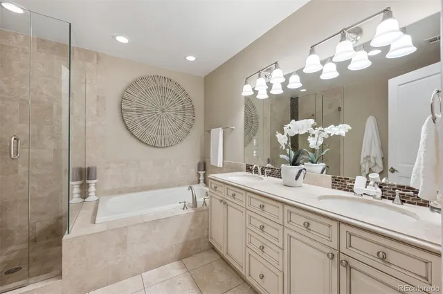 a bathroom with a double vanity sink mirror and bathtub