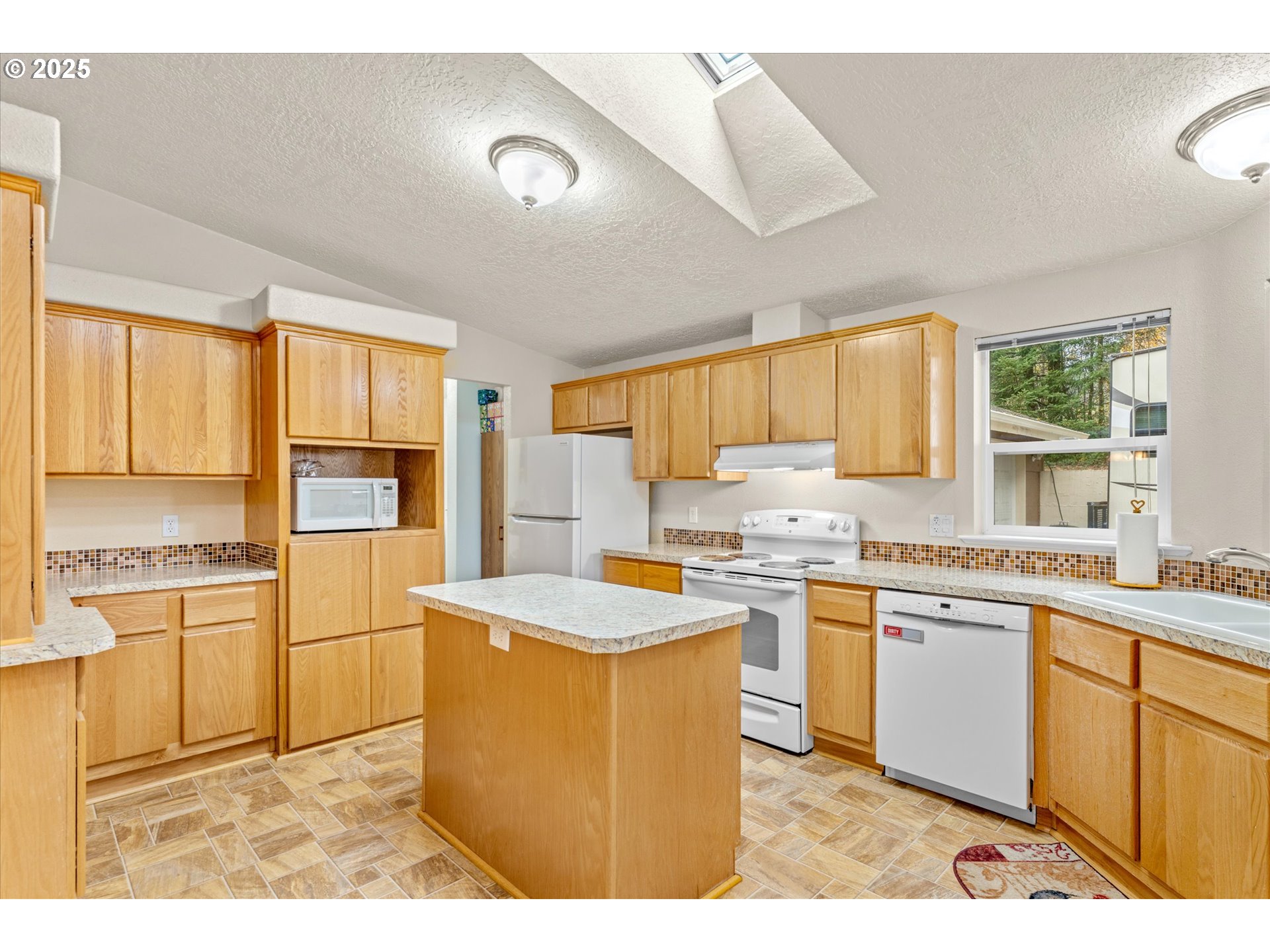 29010 Northeast 63rd Circle Camas, WA 98607 - Photo 6 of 30 a kitchen with a stove a sink a refrigerator and white cabinets with wooden floor