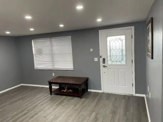 an empty room with windows and wooden floor