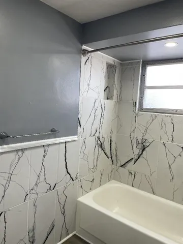 a bathroom with a bathtub and shower