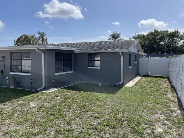 a view of a house with backyard and sitting area