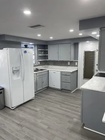 a kitchen with stainless steel appliances granite countertop a refrigerator sink and cabinets