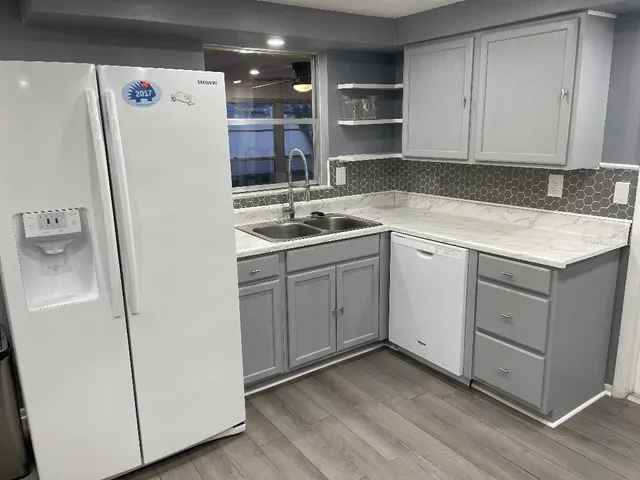 a kitchen with a sink a refrigerator and cabinets
