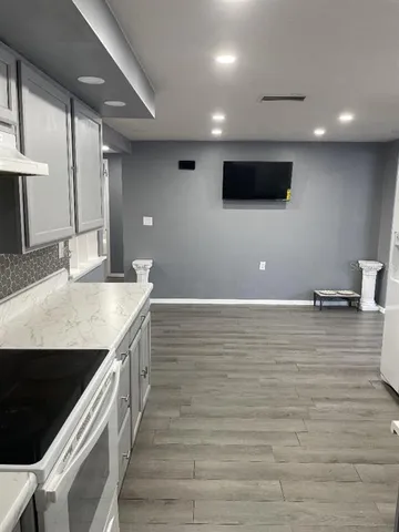 a view of a kitchen with stainless steel appliances a sink and a stove