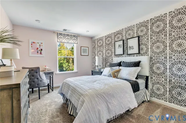 a bedroom with a bed and a table in it with window