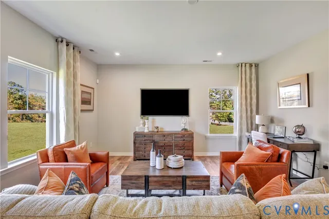 a living room with furniture a flat screen tv and a window