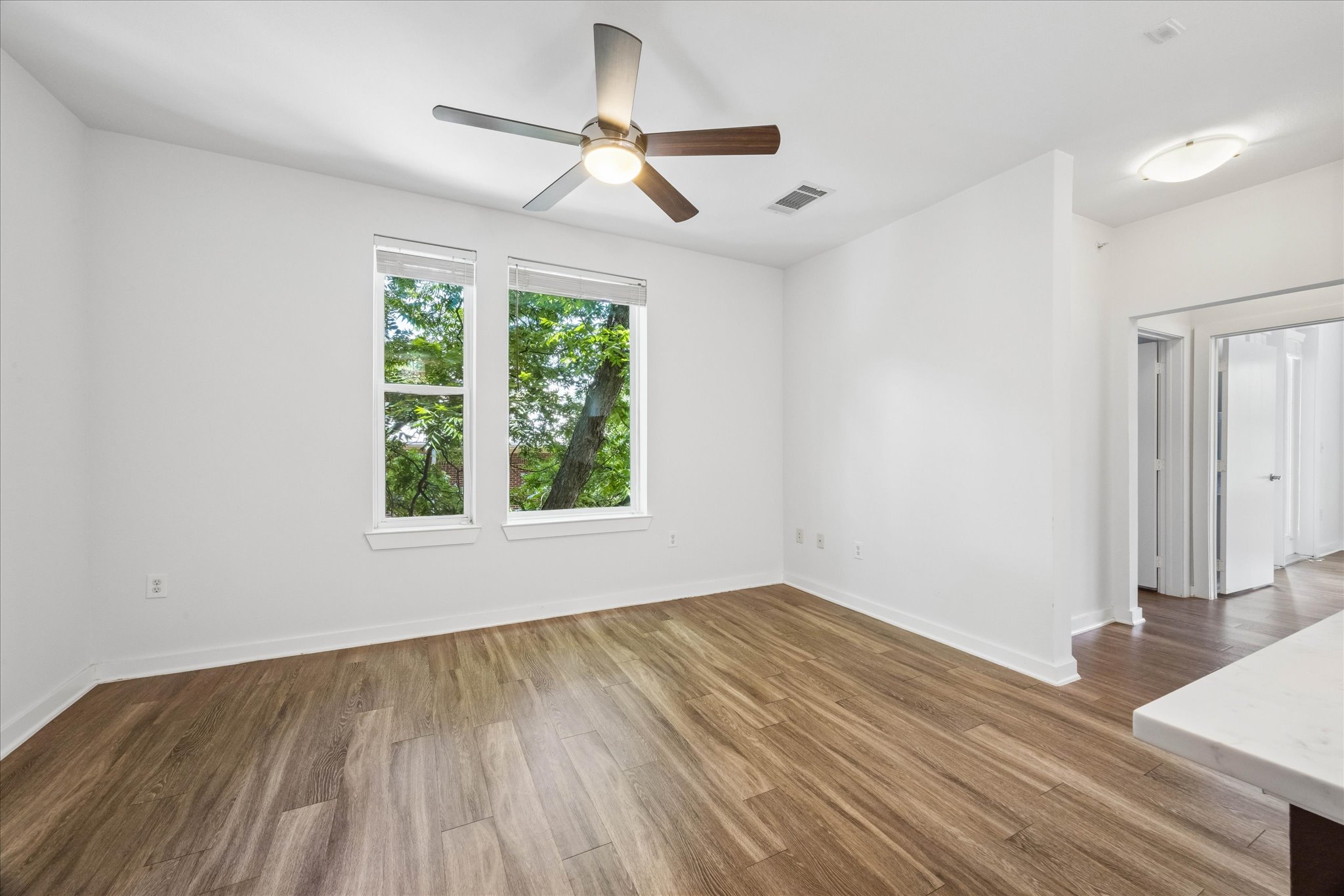1900 Barton Springs Road, Unit 4041 Austin, TX 78704 - Photo 18 of 35 Two large windows frame verdant outdoor views in this versatile living space.