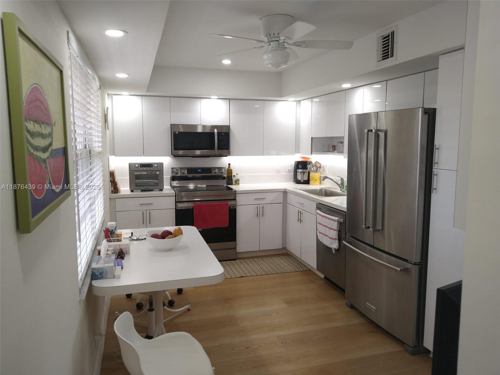 3510 Oaks Way, Unit 509 Pompano Beach, FL 33069 - Photo 19 of 36 a kitchen with stainless steel appliances a refrigerator stove microwave and sink