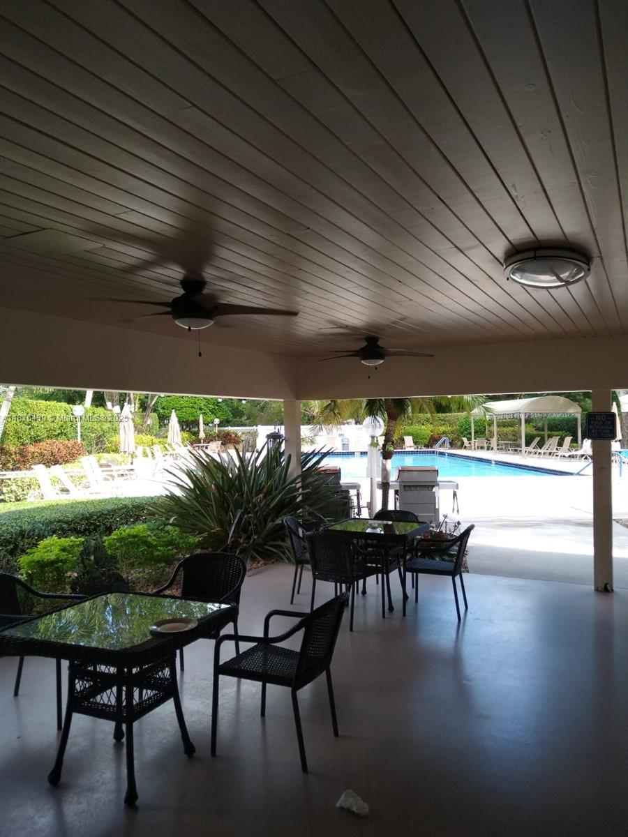 3510 Oaks Way, Unit 509 Pompano Beach, FL 33069 - Photo 2 of 36 a dining room with furniture and a garden view